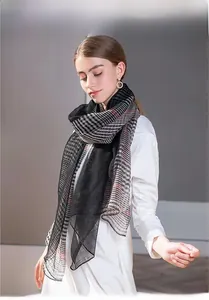 Detail of elegant silk wool blend scarf with red and black plaid pattern stitching