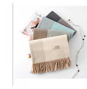 Detail of soft cashmere blend scarf with long tassels and elegant woven labels on top