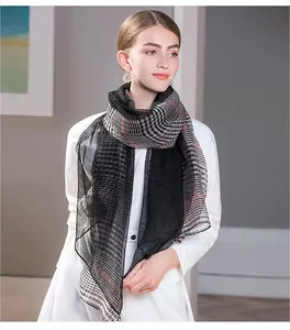 Close-up of lightweight silk wool scarf featuring classic black and white plaid patterns