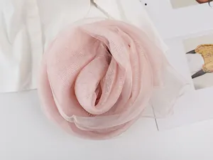 Close-up of pink silk gauze scarf folded into flower shape on a fashion magazine