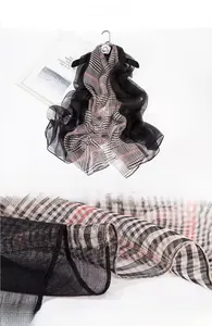 Detailed close-up of semi-transparent silk and wool blend fabric with classic plaid pattern