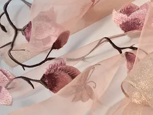 Detail view of the elegant floral embroidery and translucent silk fabric on this long scarf