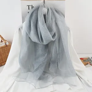 Detailed macro view of light blue pleated silk mesh shawl with sheer texture