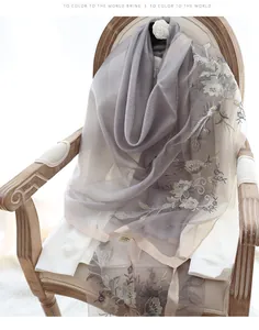 Detail of silk wool scarf with floral embroidery showing fabric texture and wash label