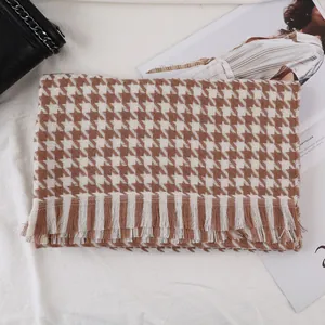Detail of classic brown houndstooth scarf with soft fringe and thick cashmere-like texture
