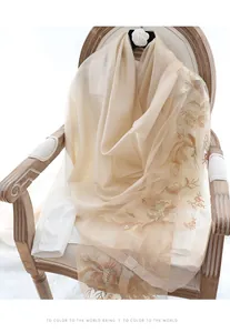 Detail of champagne silk wool scarf featuring intricate vintage floral embroidery