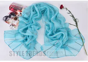 Detail of light blue silk scarf featuring translucent mesh and metallic grid texture