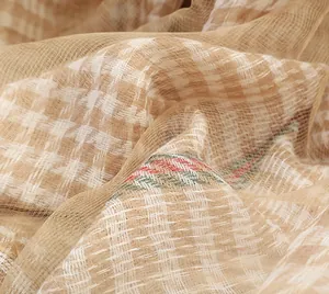 Macro shot of houndstooth silk scarf texture with detailed red and green stripe edges