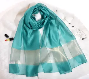 Detail of teal 100% silk sun protection shawl with golden metallic horizontal stripes