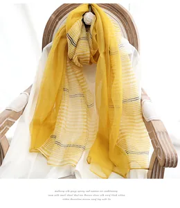 Detail of bright yellow mulberry silk gauze shawl showing sheer texture and fine stripes