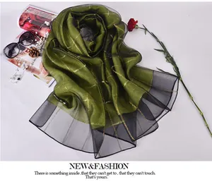 Flat lay of silk scarf with gold grid pattern, fashion magazines and pearls