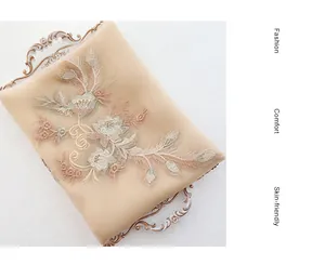 Detail of champagne gold silk wool scarf with floral embroidery and sequins on lace