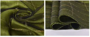 Detailed macro view of dark green silk scarf with gold grid lines and sheer organza trim
