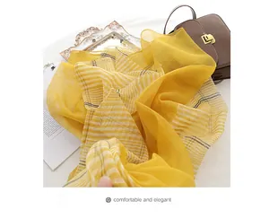 Detail of bright yellow striped silk wool scarf with a sheer texture and fine lines