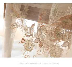 Detailed embroidery on a translucent silk wool scarf with champagne floral patterns