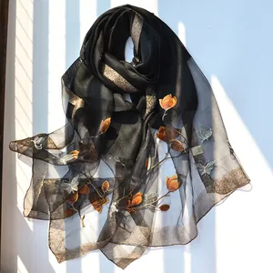 Black silk scarf with orange floral embroidery and golden shimmering border detail