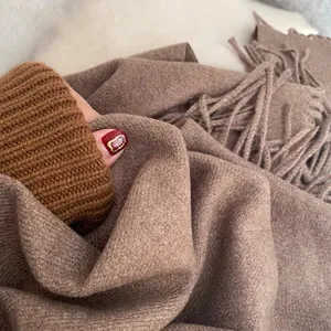 Deep brown cashmere-feel winter scarf with elegant fringe detail and soft knitted texture
