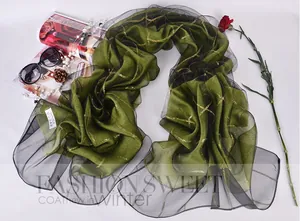 Close-up of a 100% silk label on a green checkered silk scarf with black mesh edging