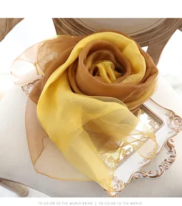 Détail d'écharpe en soie et laine dégradée pliée en forme de rose sur chaise vintage