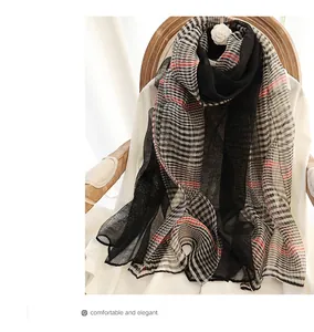 Close-up of lightweight silk wool plaid scarf draped on a chair with camellia decoration