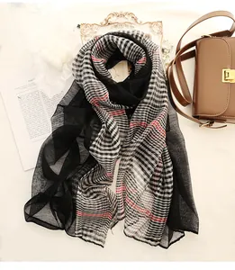 Detail shot of silk wool plaid scarf with checkered patterns and delicate wavy edges