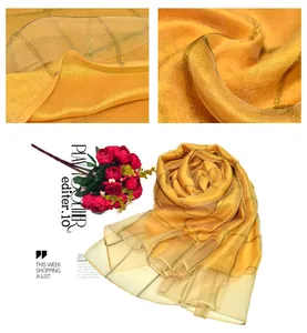Detail of silk scarf showing gold metallic checkered patterns and sheer tulle texture