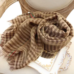 Elegant silk scarf with houndstooth and striped pattern on vintage white tray