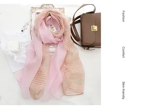 Detailed texture of pink striped silk wool scarf with leather crossbody bag setup
