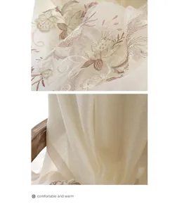 Detailed embroidery of pink flowers on translucent silk wool cream scarf fabric