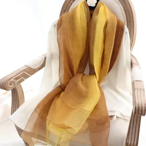 Écharpe élégante en soie et laine dégradée jaune et ambre sur une chaise vintage