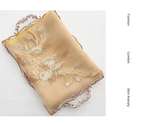 Detailed close-up of champagne silk wool scarf featuring intricate floral embroidery