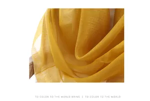 Detail of yellow silk wool scarf with textured stripes and semi-transparent drape texture