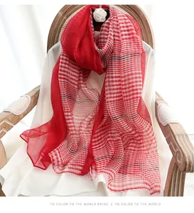 Close-up of red and white checkered silk wool scarf draped on a vintage chair
