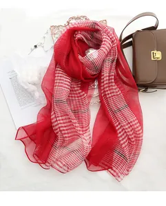 Detail of red checkered silk wool shawl with delicate stitching and lightweight texture