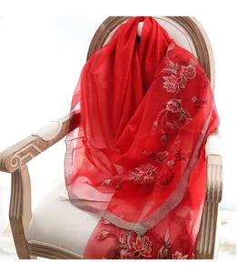Close-up of red silk wool shawl with delicate floral embroidery on classic wooden chair