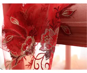 Detailed close-up of intricate red floral embroidery on luxury silk wool scarf fabric