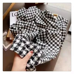 Gros plan d'une écharpe en pied-de-poule noir et blanc avec texture douce en tricot