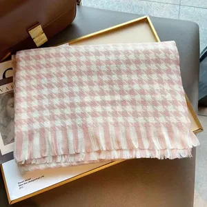 Détail d'une écharpe pied-de-poule rose avec franges douces et texture cachemire