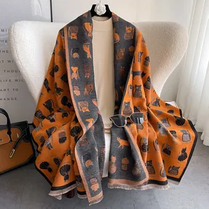 Detail view of double-sided jacquard scarf featuring cute orange and grey cat patterns