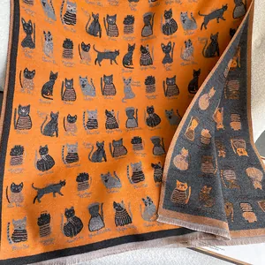 Close-up of double-sided cartoon cat scarf with orange and grey knit patterns and tassels