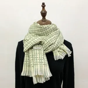 Dettaglio sciarpa scozzese beige con quadri verdi, frange ed etichetta Feel Scarf