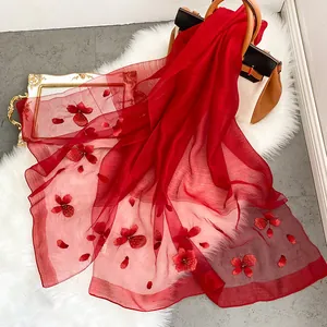 Red silk wool shawl with 3D floral embroidery and rhinestones on plush background