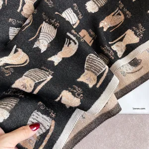 Close-up of knit fabric showing double-sided cartoon cat patterns on a warm scarf