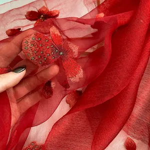 Luxurious red silk wool scarf with intricate floral embroidery and sheer texture