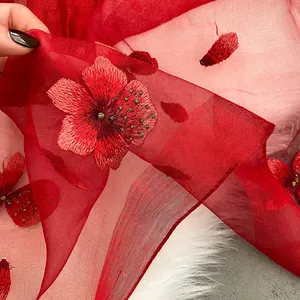 Close-up of red silk wool scarf with 3D floral embroidery and golden bead details
