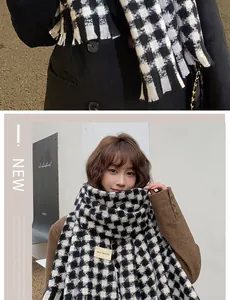 Detailed macro view of black and white houndstooth scarf with fringe and fabric tag