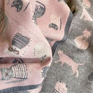 Close-up of double-sided cartoon cat scarf showing pink and grey jacquard knit texture