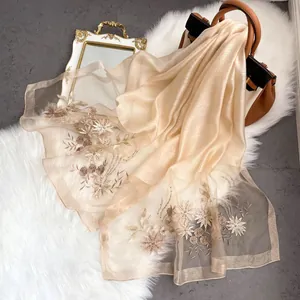 Close-up of champagne silk shawl featuring delicate floral embroidery and sequins