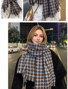 Detail of blue houndstooth scarf with tassels and label on a wool coat