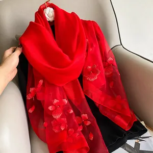 Detailed view of red silk wool scarf with 3D floral embroidery and bead accents